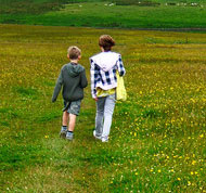 Two children walking in a field